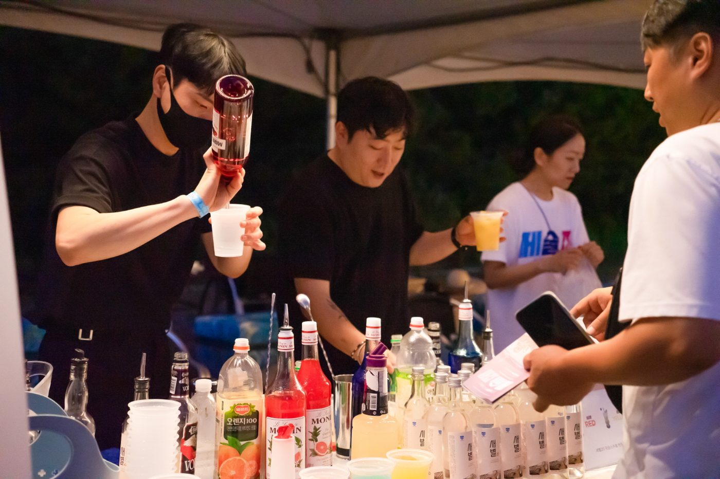 칵테일을 만들어 관람객에게 건네는 바텐더